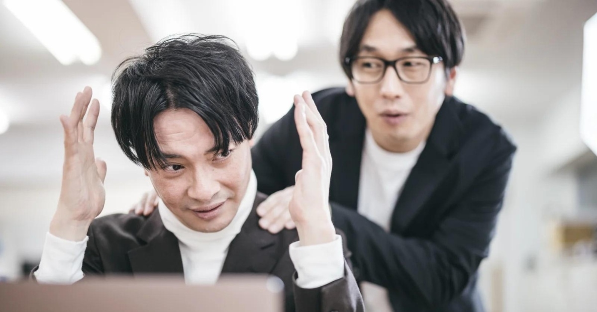 悩む男性とその肩に手を置く男性