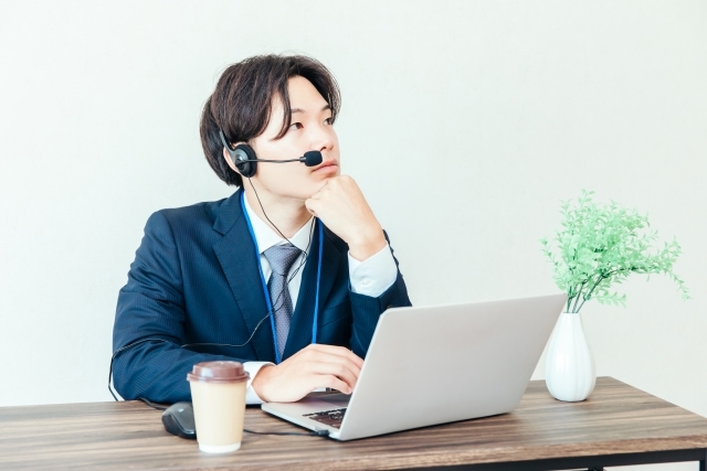 マイクを付けて電話対応をする社員