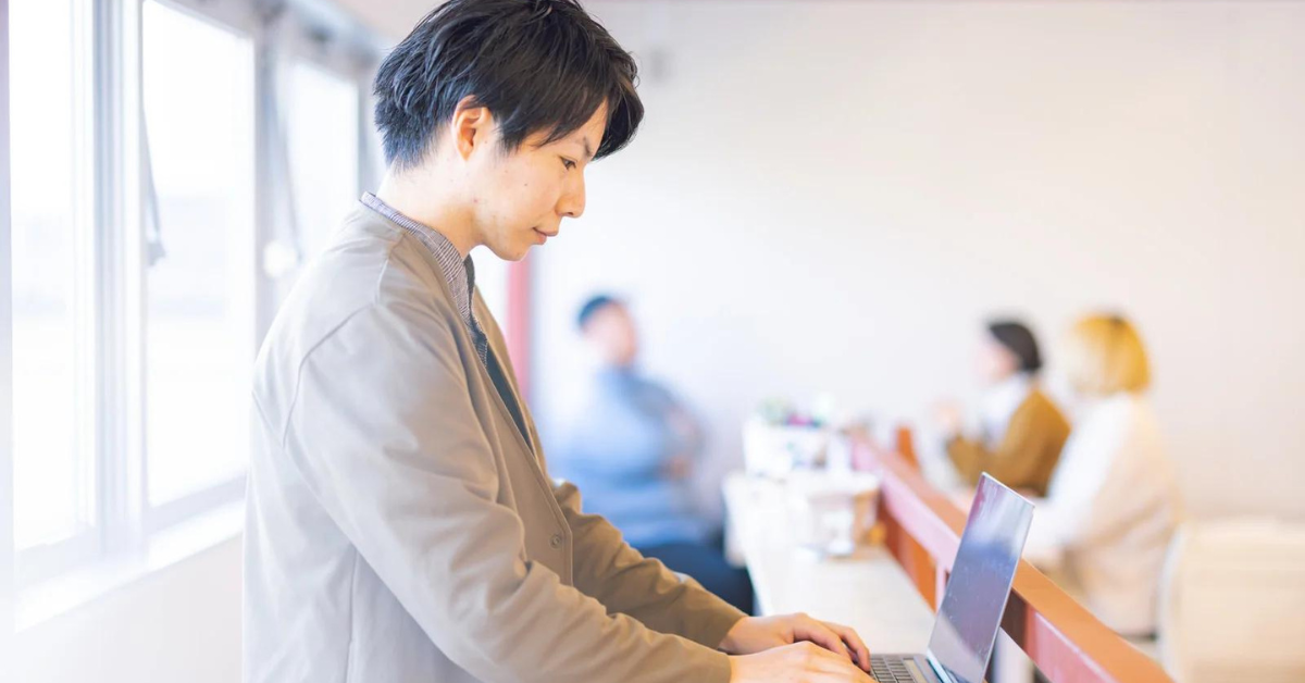 明るい部屋でPC作業をする男性社員